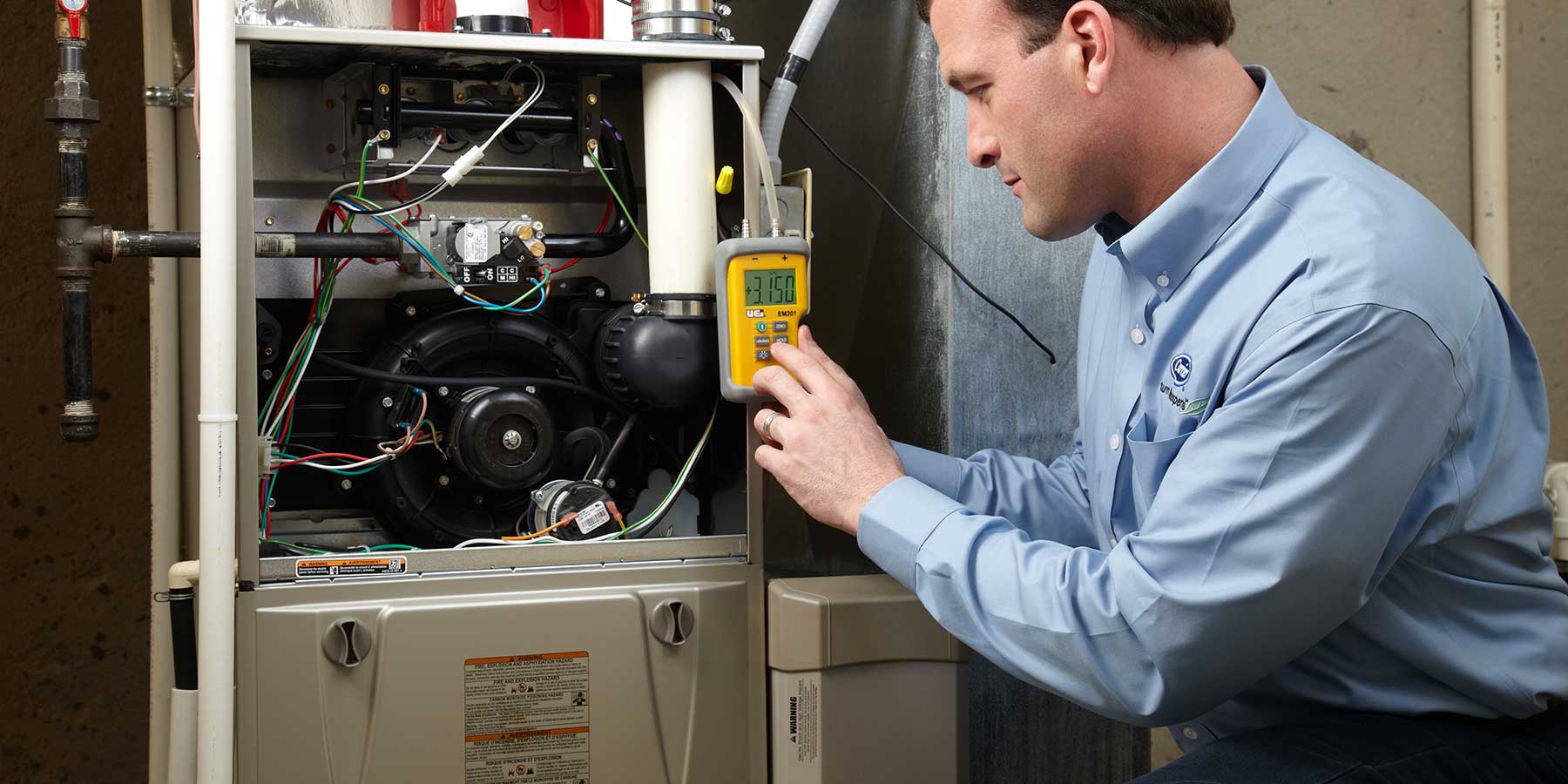 Technician testing components inside a residential furnace