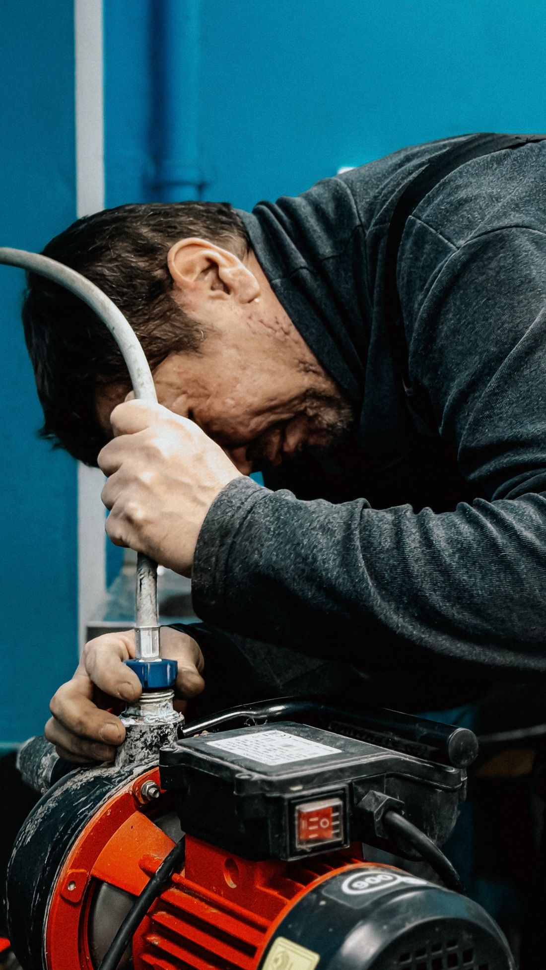 Technician adjusting a household water pump indoors